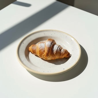 Cream speckled side plate having croissants for breakfast